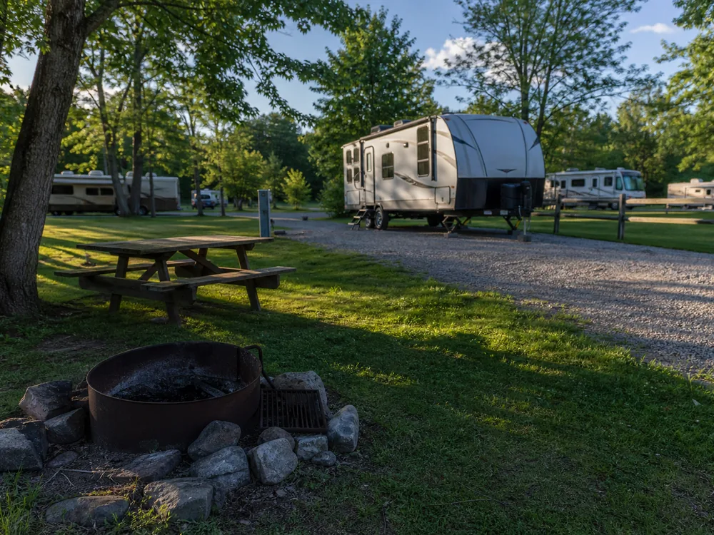 Fire ring and picnic table at an RV park site in late afternoon light